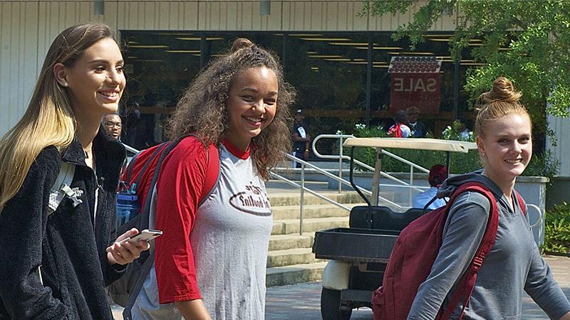 Two female studnets walking on campus